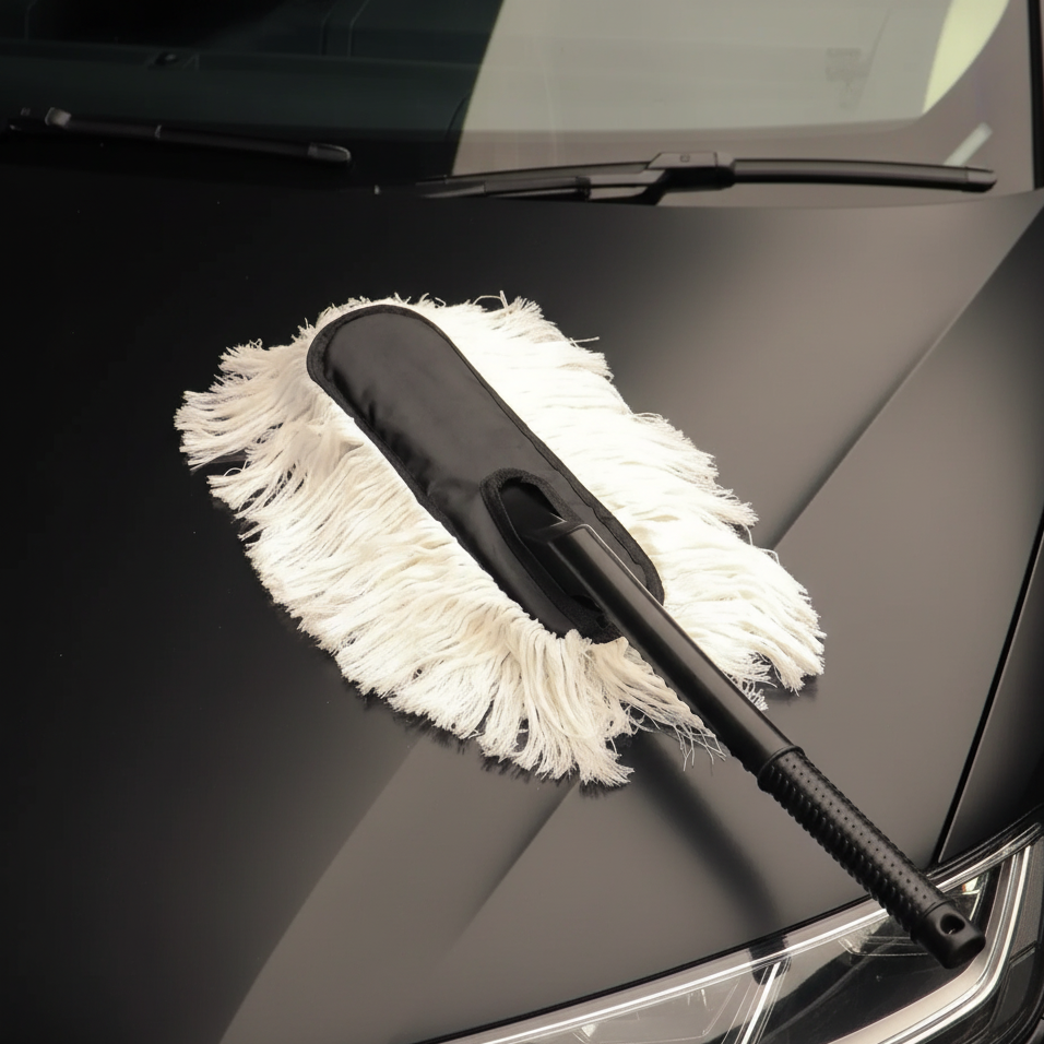 AutoPrro Car cleaning brush with white bristle pad on a black car hood