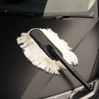 AutoPrro Car cleaning brush with white bristle pad on a black car hood